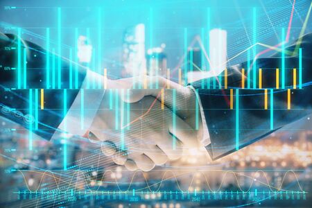 Double exposure of financial chart on cityscape background with two businessmen handshake. Concept of financial analysis and investment opportunitiesの写真素材