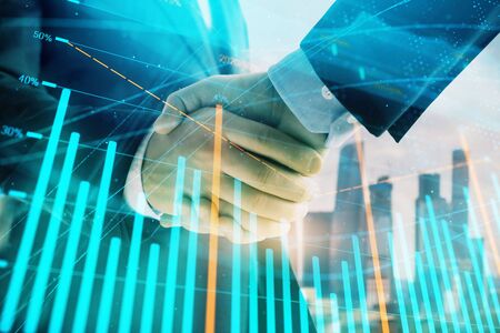 Double exposure of financial graph on cityscape background with two businessman handshake. Concept of stock market dealの写真素材