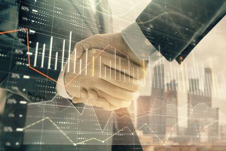 Double exposure of financial graph on cityscape background with two businessman handshake. Concept of stock market dealの写真素材