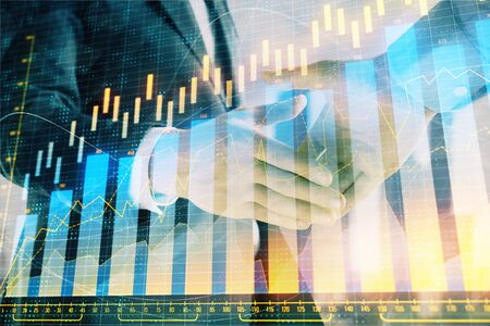 Double exposure of financial graph on cityscape background with two businessman handshake. Concept of stock market dealの写真素材