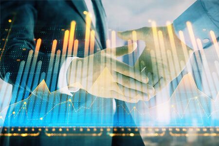 Double exposure of financial graph on cityscape background with two businessman handshake. Concept of stock market dealの写真素材