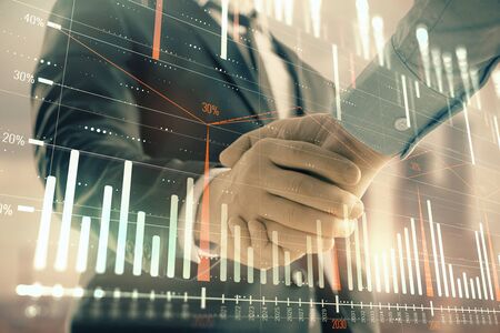 Double exposure of financial graph on cityscape background with two businessman handshake. Concept of stock market dealの写真素材