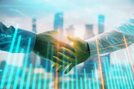 Double exposure of financial graph on cityscape background with two businessman handshake. Concept of stock market dealの写真素材