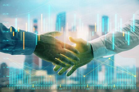 Double exposure of financial graph on cityscape background with two businessman handshake. Concept of stock market dealの写真素材