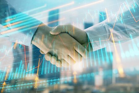 Double exposure of financial graph on cityscape background with two businessman handshake. Concept of stock market dealの写真素材
