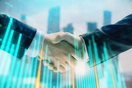 Double exposure of financial graph on cityscape background with two businessman handshake. Concept of stock market dealの写真素材