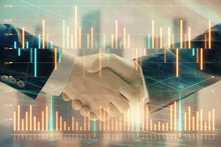 Double exposure of financial graph on cityscape background with two businessman handshake. Concept of stock market dealの写真素材