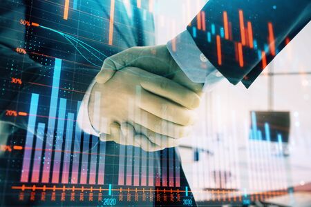 Multi exposure of financial graph on office background with two businessmen handshake. Concept of success in businessの写真素材