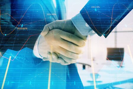 Multi exposure of financial graph on office background with two businessmen handshake. Concept of success in businessの写真素材
