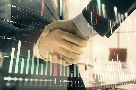 Multi exposure of financial graph on office background with two businessmen handshake. Concept of success in businessの写真素材
