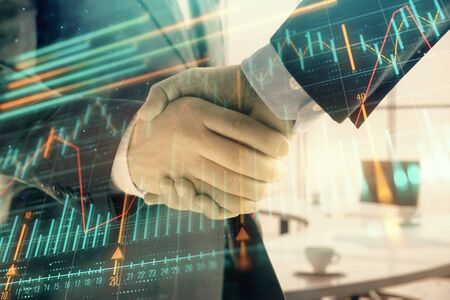 Multi exposure of financial graph on office background with two businessmen handshake. Concept of success in businessの写真素材