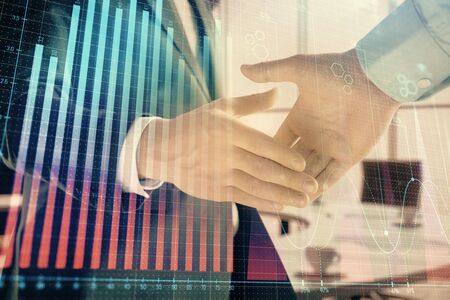 Multi exposure of financial graph on office background with two businessmen handshake. Concept of success in businessの写真素材