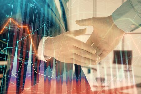 Multi exposure of financial graph on office background with two businessmen handshake. Concept of success in businessの写真素材