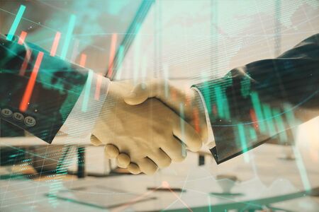 Multi exposure of financial chart and map on office background with two businessmen handshake. Concept of success in businessの写真素材