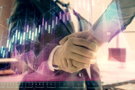 Multi exposure of financial graph on office background with two businessmen handshake. Concept of success in businessの写真素材
