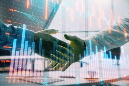 Multi exposure of financial graph on office background with two businessmen handshake. Concept of success in businessの写真素材