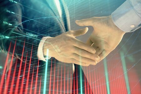 Multi exposure of forex graph on abstract background with two businessmen handshake. Concept of success on stock marketの写真素材