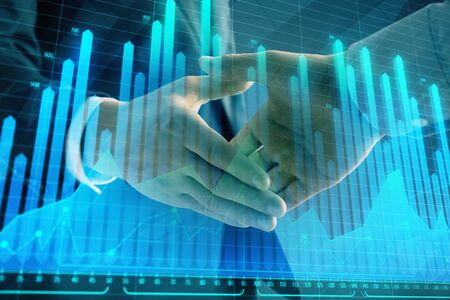 Multi exposure of forex graph on abstract background with two businessmen handshake. Concept of success on stock marketの写真素材
