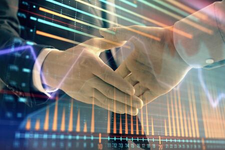 Multi exposure of forex graph on abstract background with two businessmen handshake. Concept of success on stock marketの写真素材
