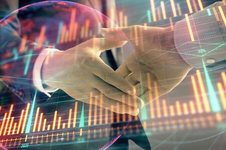 Multi exposure of forex graph and world map on abstract background with two businessmen handshake. Concept of success on international marketsの写真素材