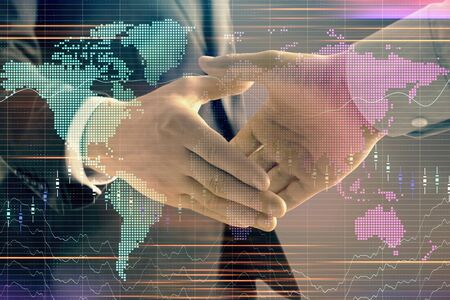 Multi exposure of forex graph and world map on abstract background with two businessmen handshake. Concept of success on international marketsの写真素材