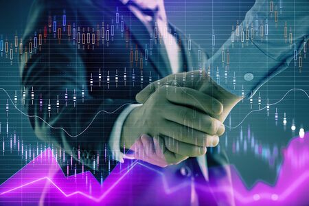 Multi exposure of forex graph on abstract background with two businessmen handshake. Concept of success on stock marketの写真素材