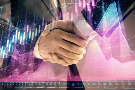Multi exposure of forex graph on abstract background with two businessmen handshake. Concept of success on stock marketの写真素材
