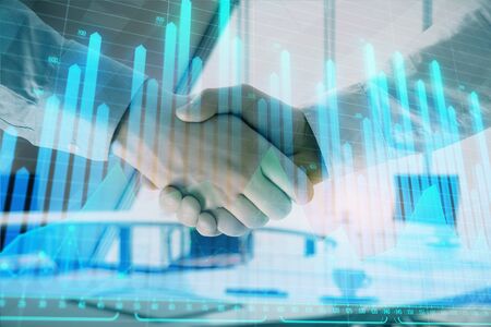 Multi exposure of financial graph on office background with two businessmen handshake. Concept of success in businessの写真素材