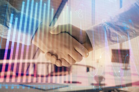 Multi exposure of financial graph on office background with two businessmen handshake. Concept of success in businessの写真素材
