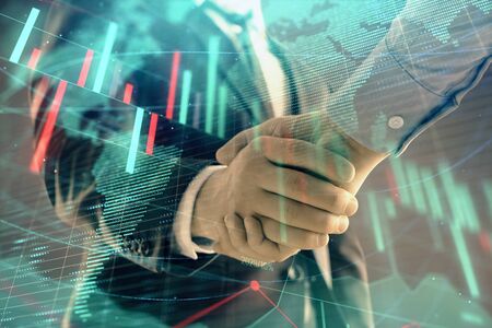 Multi exposure of forex graph and world map on abstract background with two businessmen handshake. Concept of success on international marketsの写真素材