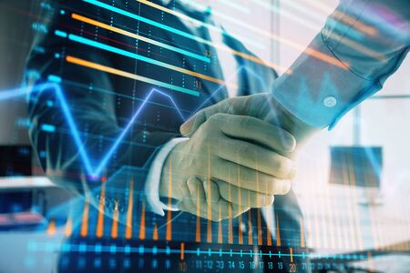 Multi exposure of financial graph on office background with two businessmen handshake. Concept of success in businessの写真素材