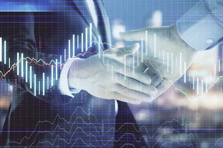 Double exposure of financial chart on cityscape background with two businessmen handshake. Concept of financial analysis and investment opportunitiesの写真素材