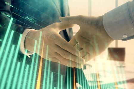 Multi exposure of financial graph on office background with two businessmen handshake. Concept of success in businessの写真素材