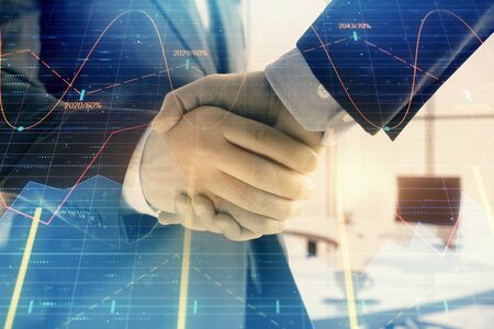 Multi exposure of financial graph on office background with two businessmen handshake. Concept of success in businessの写真素材