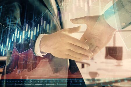 Multi exposure of financial graph on office background with two businessmen handshake. Concept of success in businessの写真素材