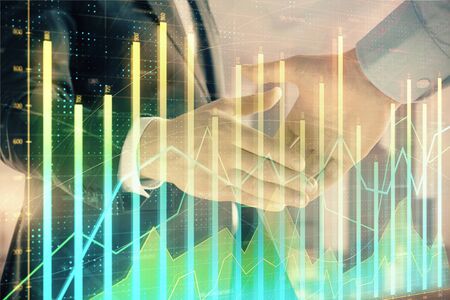Double exposure of financial graph on cityscape background with two businessman handshake. Concept of stock market dealの写真素材