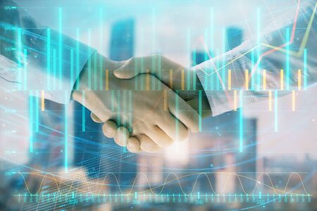 Double exposure of financial graph on cityscape background with two businessman handshake. Concept of stock market dealの写真素材