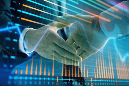 Multi exposure of forex graph on abstract background with two businessmen handshake. Concept of success on stock marketの写真素材