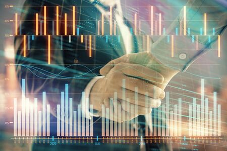 Double exposure of financial chart on cityscape background with two businessmen handshake. Concept of financial analysis and investment opportunitiesの写真素材