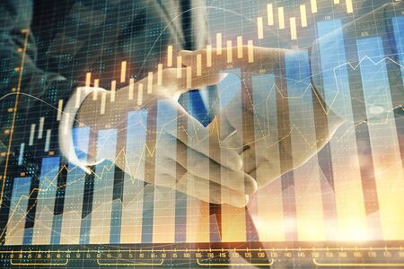 Double exposure of financial chart on cityscape background with two businessmen handshake. Concept of financial analysis and investment opportunitiesの写真素材
