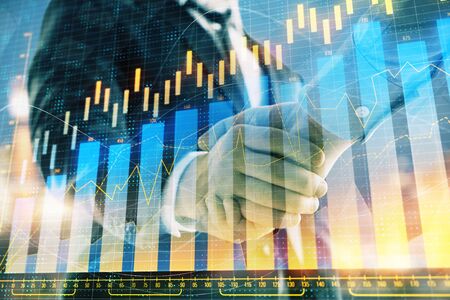 Double exposure of financial chart on cityscape background with two businessmen handshake. Concept of financial analysis and investment opportunitiesの写真素材