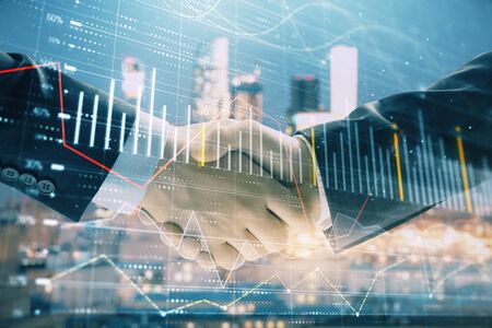 Double exposure of financial chart on cityscape background with two businessmen handshake. Concept of financial analysis and investment opportunitiesの写真素材