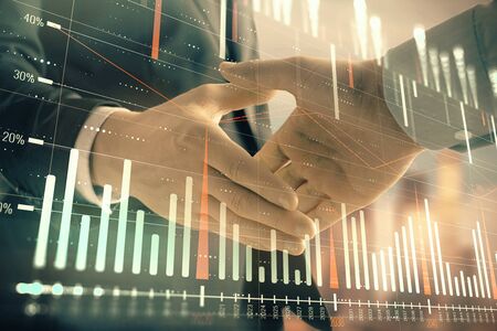 Double exposure of financial graph on cityscape background with two businessman handshake. Concept of stock market dealの写真素材