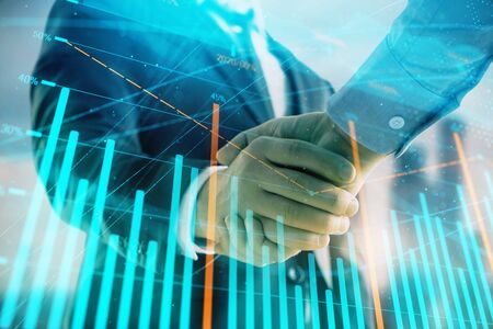 Double exposure of financial graph on cityscape background with two businessman handshake. Concept of stock market dealの写真素材