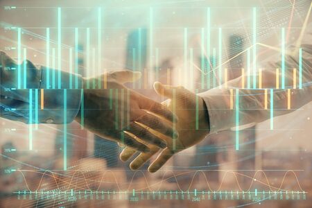 Double exposure of financial graph on cityscape background with two businessman handshake. Concept of stock market dealの写真素材