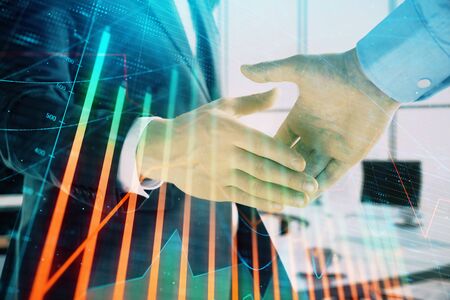 Multi exposure of financial graph on office background with two businessmen handshake. Concept of success in businessの写真素材