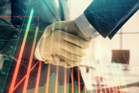 Multi exposure of financial graph on office background with two businessmen handshake. Concept of success in businessの写真素材