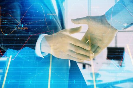 Multi exposure of financial graph on office background with two businessmen handshake. Concept of success in businessの写真素材