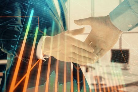 Multi exposure of financial graph on office background with two businessmen handshake. Concept of success in businessの写真素材