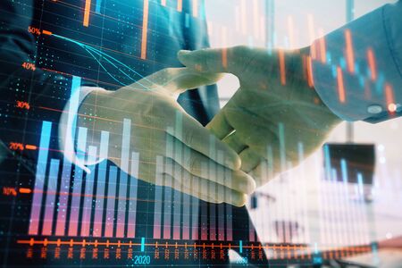 Multi exposure of financial graph on office background with two businessmen handshake. Concept of success in businessの写真素材